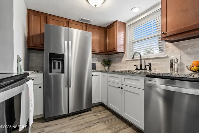 a kitchen with a refrigerator sink and cabinets