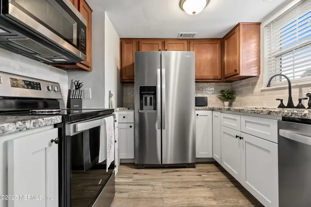 a kitchen with stainless steel appliances a refrigerator sink and microwave
