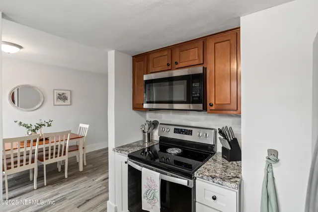 a kitchen with granite countertop a stove and a wooden floor