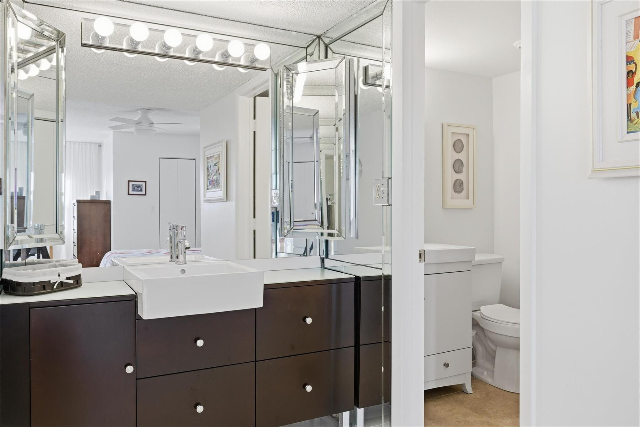 3930 Inverrary Boulevard, Unit 605D Fort Lauderdale, FL 33319 - Photo 23 of 52 a bathroom with a sink a toilet and a mirror