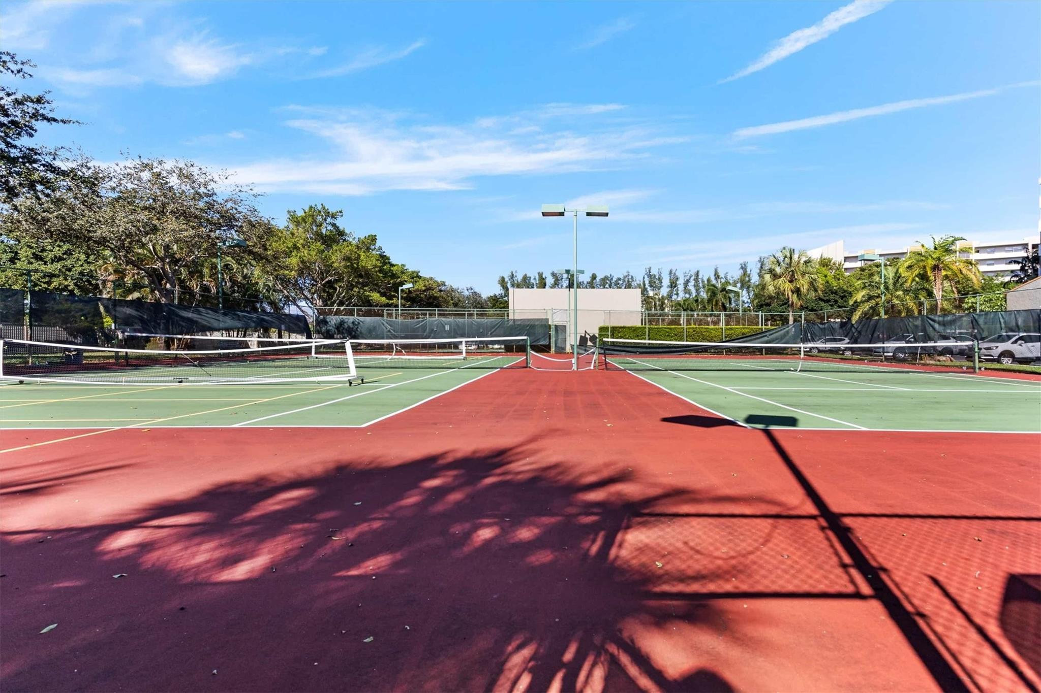 3930 Inverrary Boulevard, Unit 605D Fort Lauderdale, FL 33319 - Photo 46 of 52 a view of a tennis ground and large trees