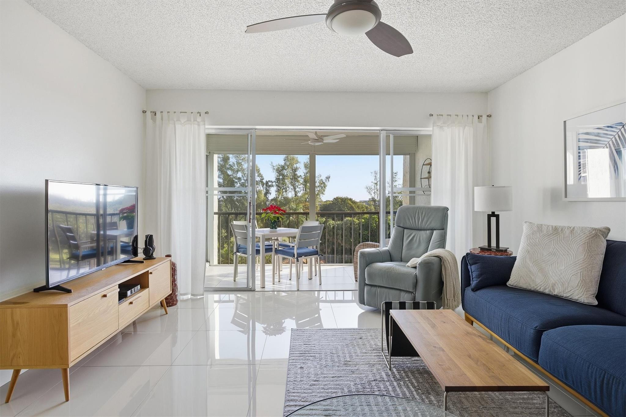 3930 Inverrary Boulevard, Unit 605D Fort Lauderdale, FL 33319 - Photo 5 of 52 a living room with furniture and a flat screen tv