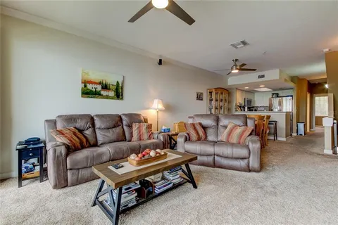 a living room with furniture a ceiling fan and a rug