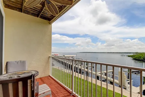 a balcony of a house with wooden floor and outdoor seating