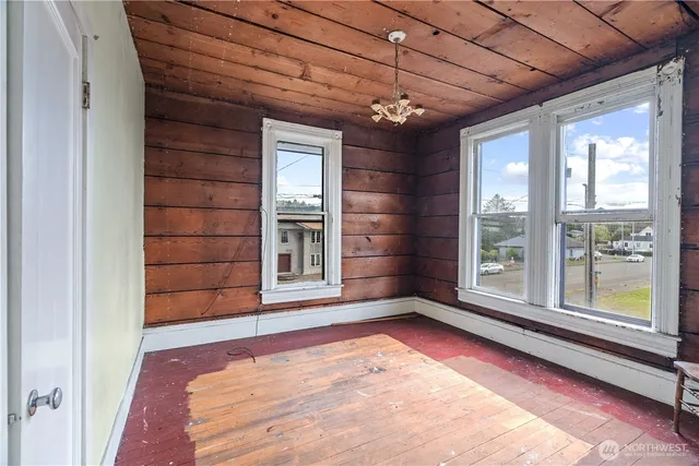 a view of a room with a chandelier and wooden floor