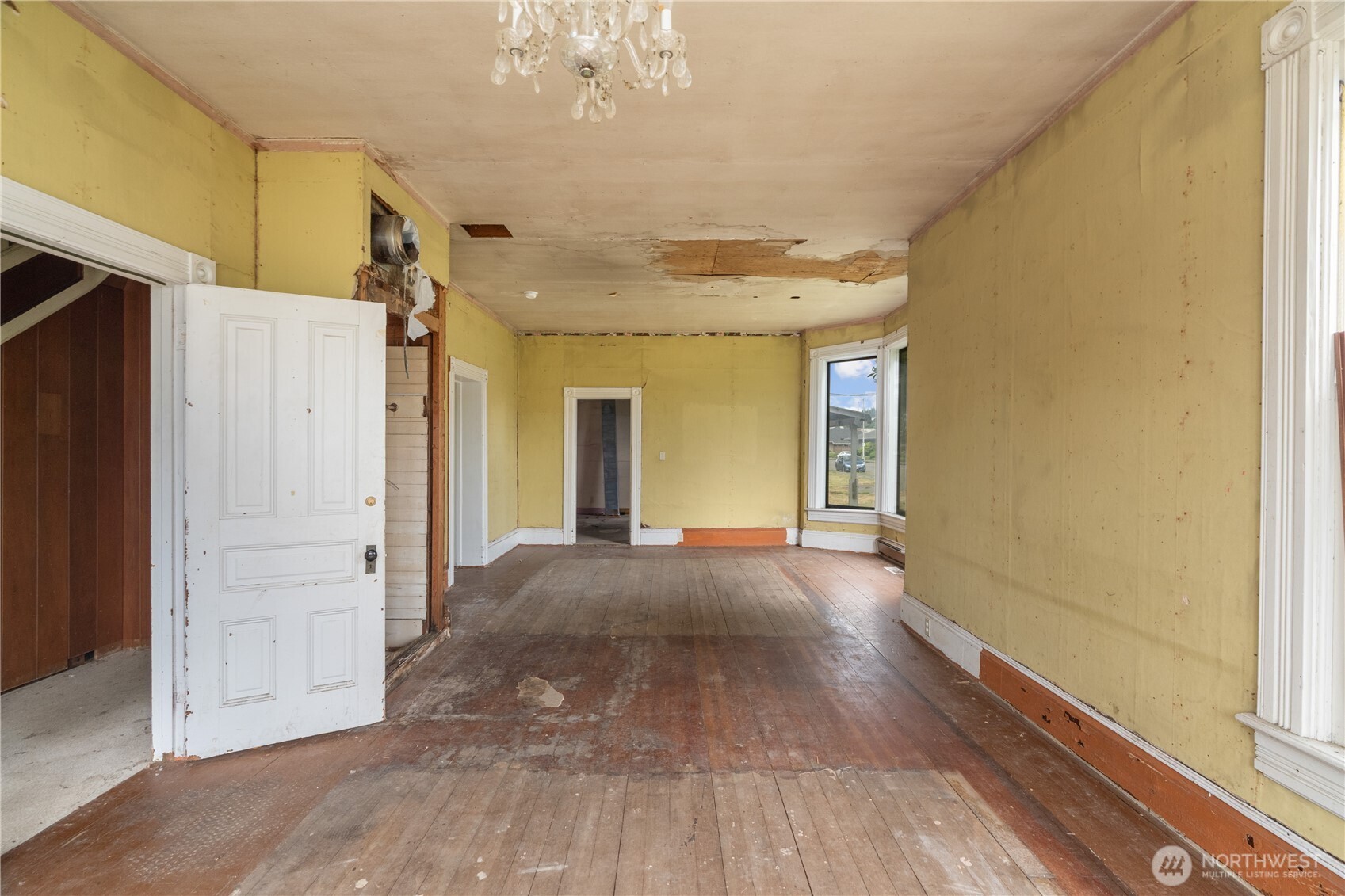 504 9th Street Hoquiam, WA 98550 - Photo 7 of 40 a view of a hallway with wooden floor and chandelier