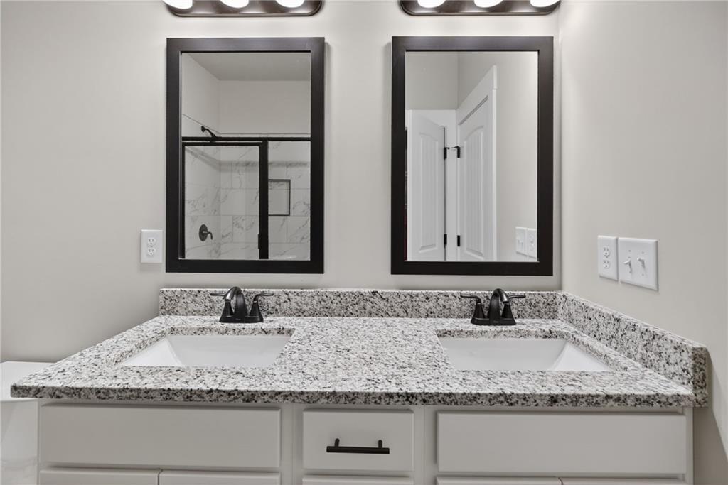 1549 Winn Road Douglasville, GA 30134 - Photo 23 of 36 a bathroom with double vanity sinks granite vanity and a mirror