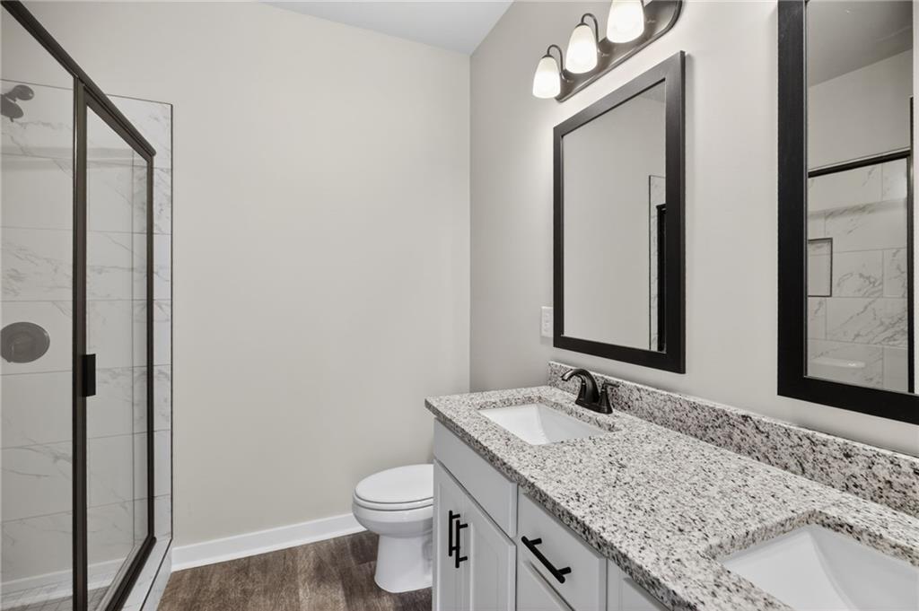 1549 Winn Road Douglasville, GA 30134 - Photo 24 of 36 a bathroom with a granite countertop sink toilet and mirror