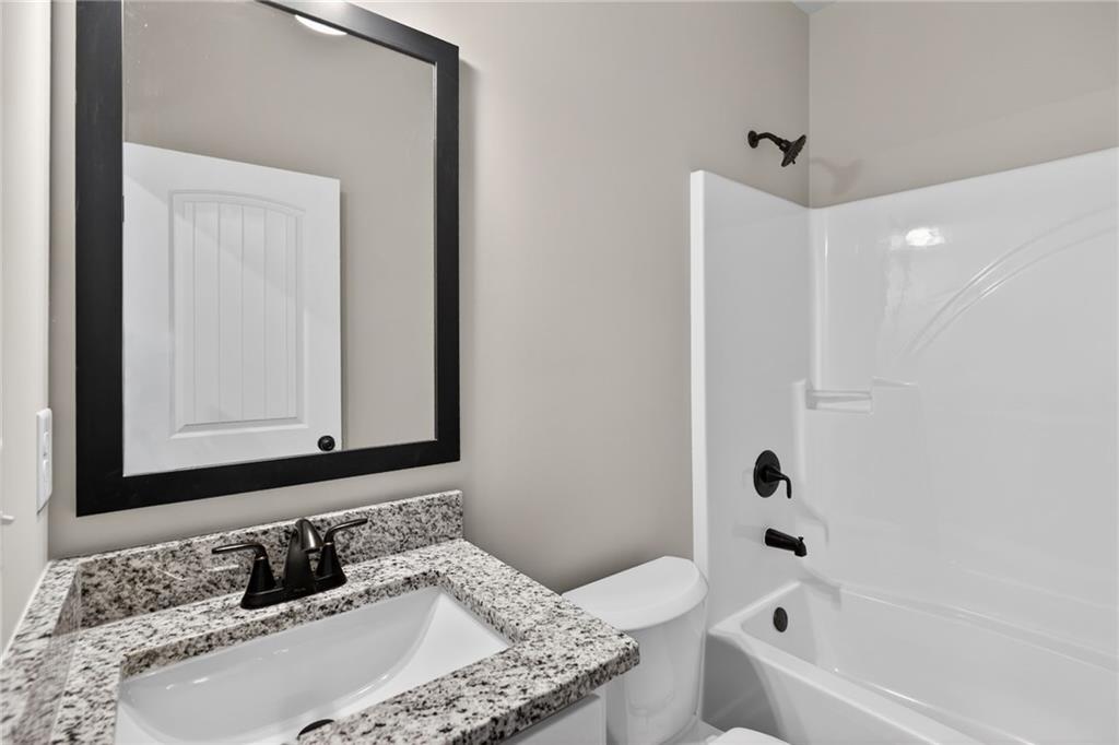 1549 Winn Road Douglasville, GA 30134 - Photo 28 of 36 a bathroom with a granite countertop tub sink and mirror