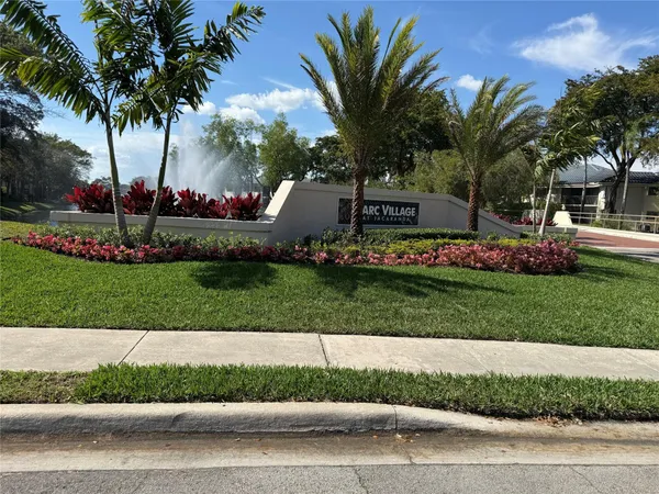 a front view of a house with a garden and palm tree