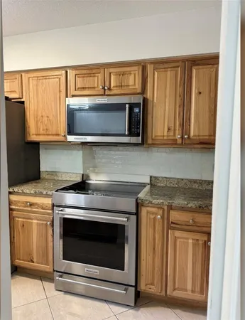 a kitchen with wooden cabinets and a stove top oven