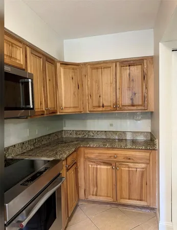 a living room with stainless steel appliances kitchen island granite countertop a refrigerator and a stove