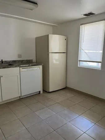 a view of a kitchen with a refrigerator and window