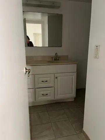 a bathroom with a granite countertop sink and mirror