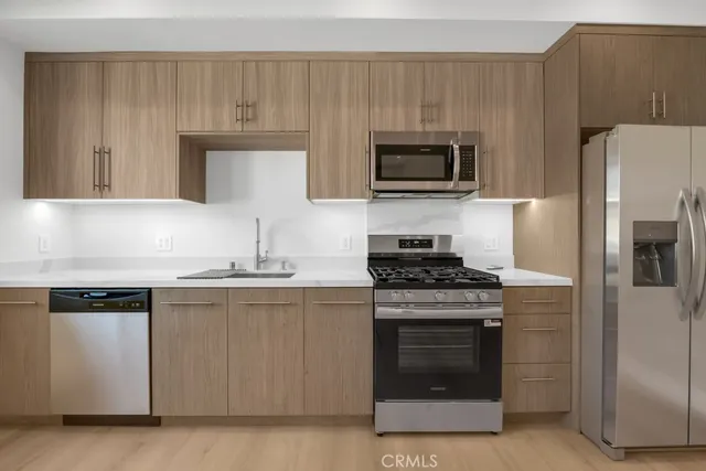 a kitchen with granite countertop a stove top oven and cabinets