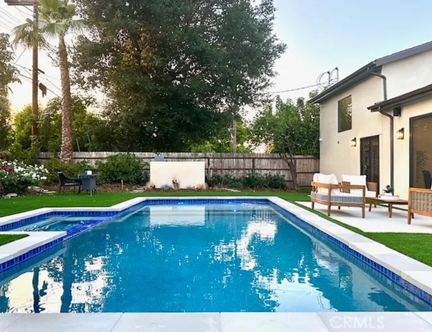 a view of a house with swimming pool and sitting area