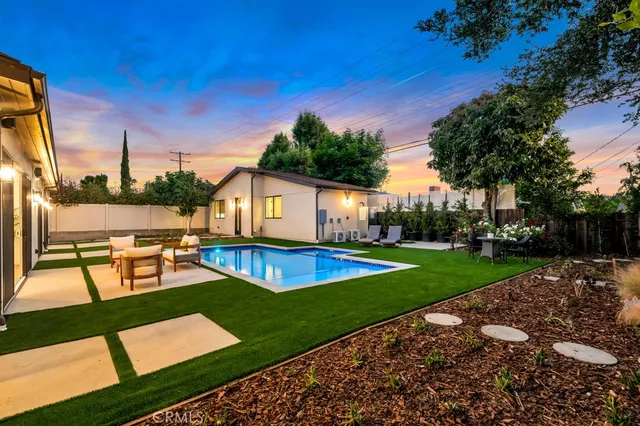 a view of a house with swimming pool and sitting area