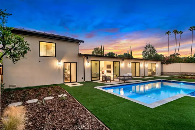 a view of a house with pool and a yard