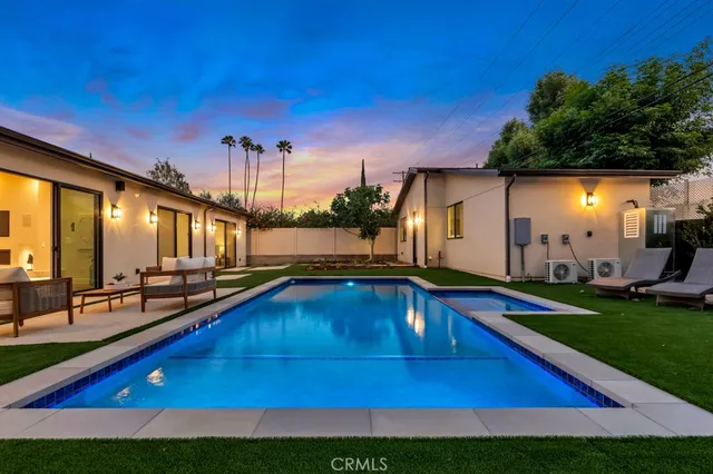 a view of swimming pool with outdoor seating and yard in the back