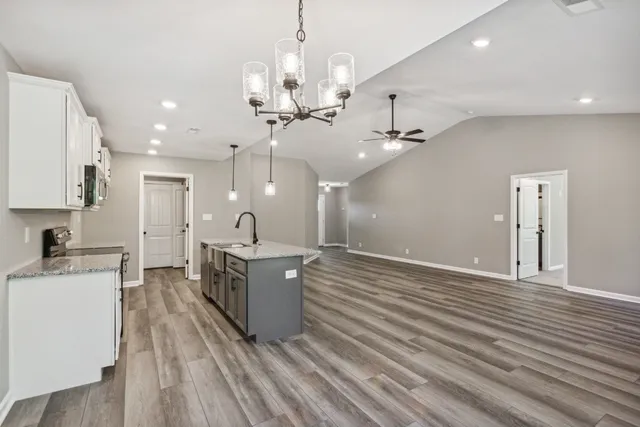 a kitchen with stainless steel appliances granite countertop a stove a sink and a microwave