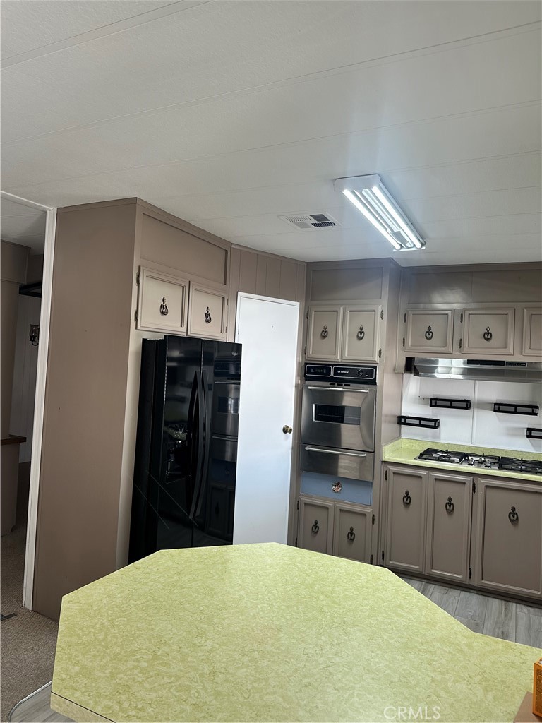 881 North Lake Street, Unit 301 Hemet, CA 92544 - Photo 9 of 21 a kitchen with stainless steel appliances kitchen island granite countertop a refrigerator and a sink