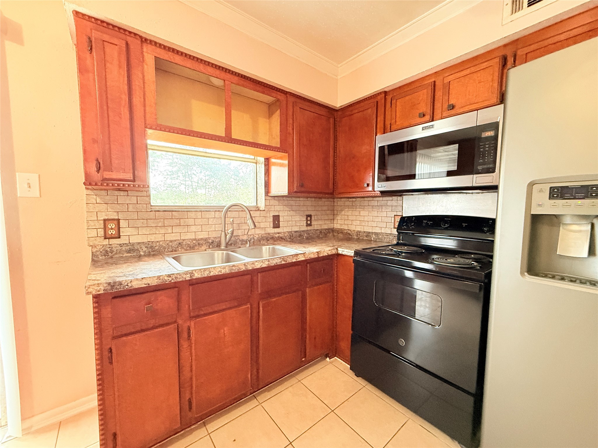 208 Laurie Lane Willis, TX 77378 - Photo 6 of 35 a kitchen with stainless steel appliances granite countertop a stove a sink and a microwave