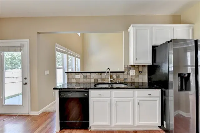 a kitchen with stainless steel appliances white cabinets and a granite counter tops