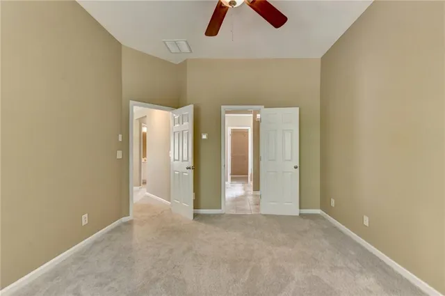 an empty room with ceiling fan and window
