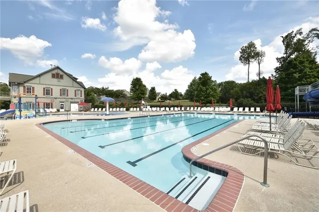 a view of a house with swimming pool and sitting area