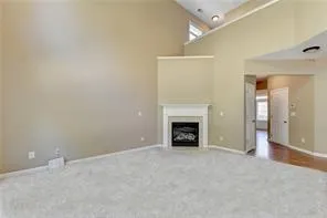 an empty room with a fireplace and a chandelier fan