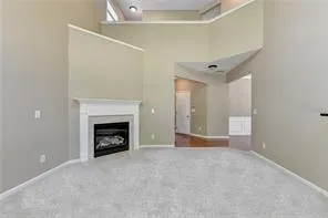 a view of an empty room with a fireplace and a window