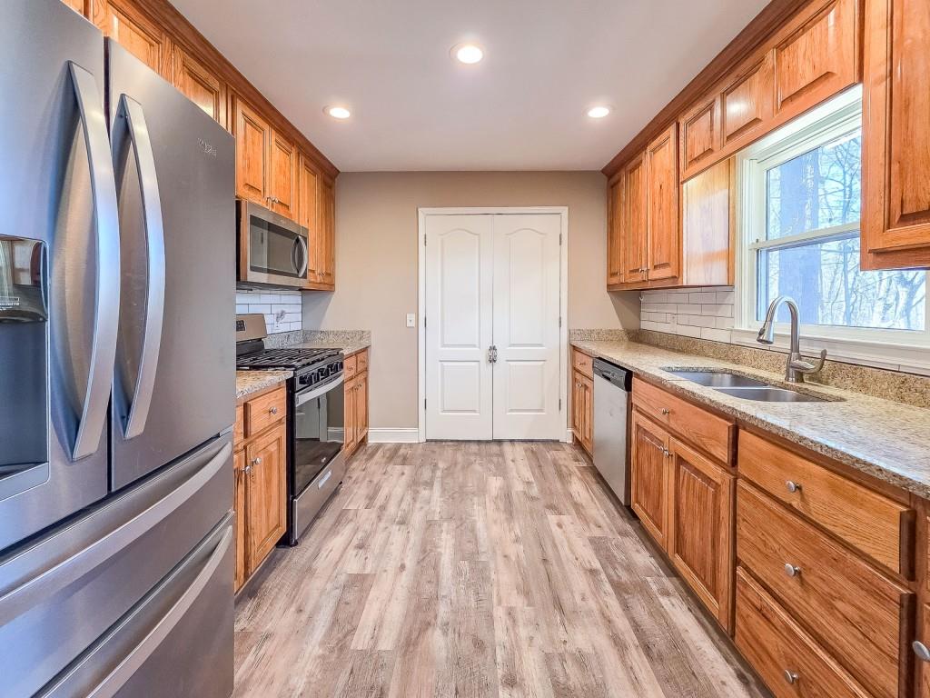 165 Horseshoe Bend Jasper, GA 30143 - Photo 14 of 44 a kitchen with stainless steel appliances granite countertop a refrigerator a sink dishwasher a oven with wooden cabinets and floor