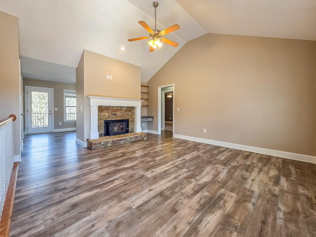 165 Horseshoe Bend Jasper, GA 30143 - Photo 7 of 44 an empty room with wooden floor a chandelier fan and a fireplace