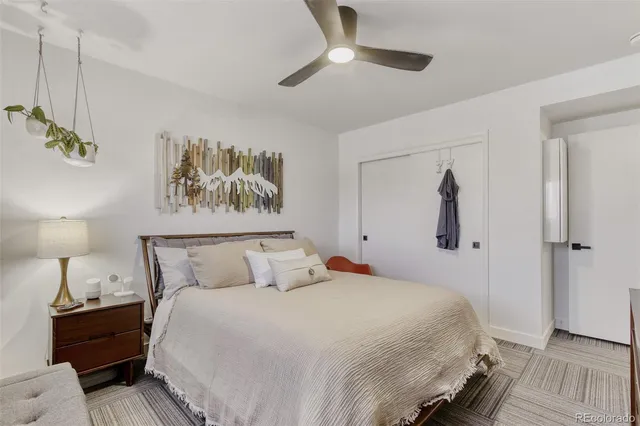 a bedroom with a bed and a painting on the wall