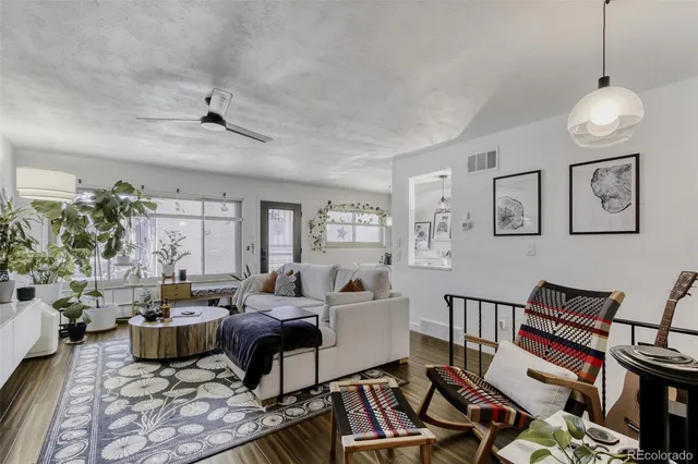 a living room with lots of furniture and a ceiling fan