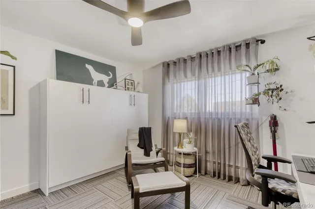 a living room with furniture a desk and chair with wooden floor