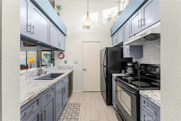 a kitchen with stainless steel appliances granite countertop a stove a sink and a microwave