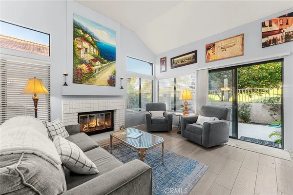 a living room with furniture fireplace and a large window
