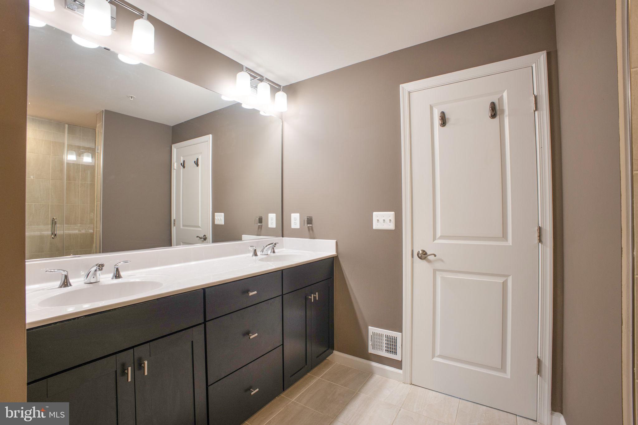 10517 Sally Ride Lane Lanham, MD 20706 - Photo 19 of 37 a bathroom with a double vanity sink and mirror
