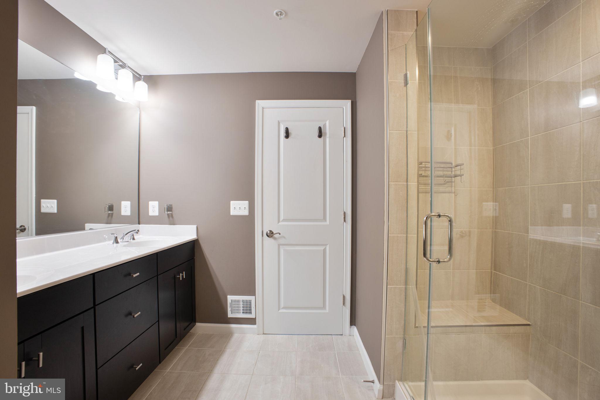 10517 Sally Ride Lane Lanham, MD 20706 - Photo 20 of 37 a spacious bathroom with a double vanity sink a shower and a mirror