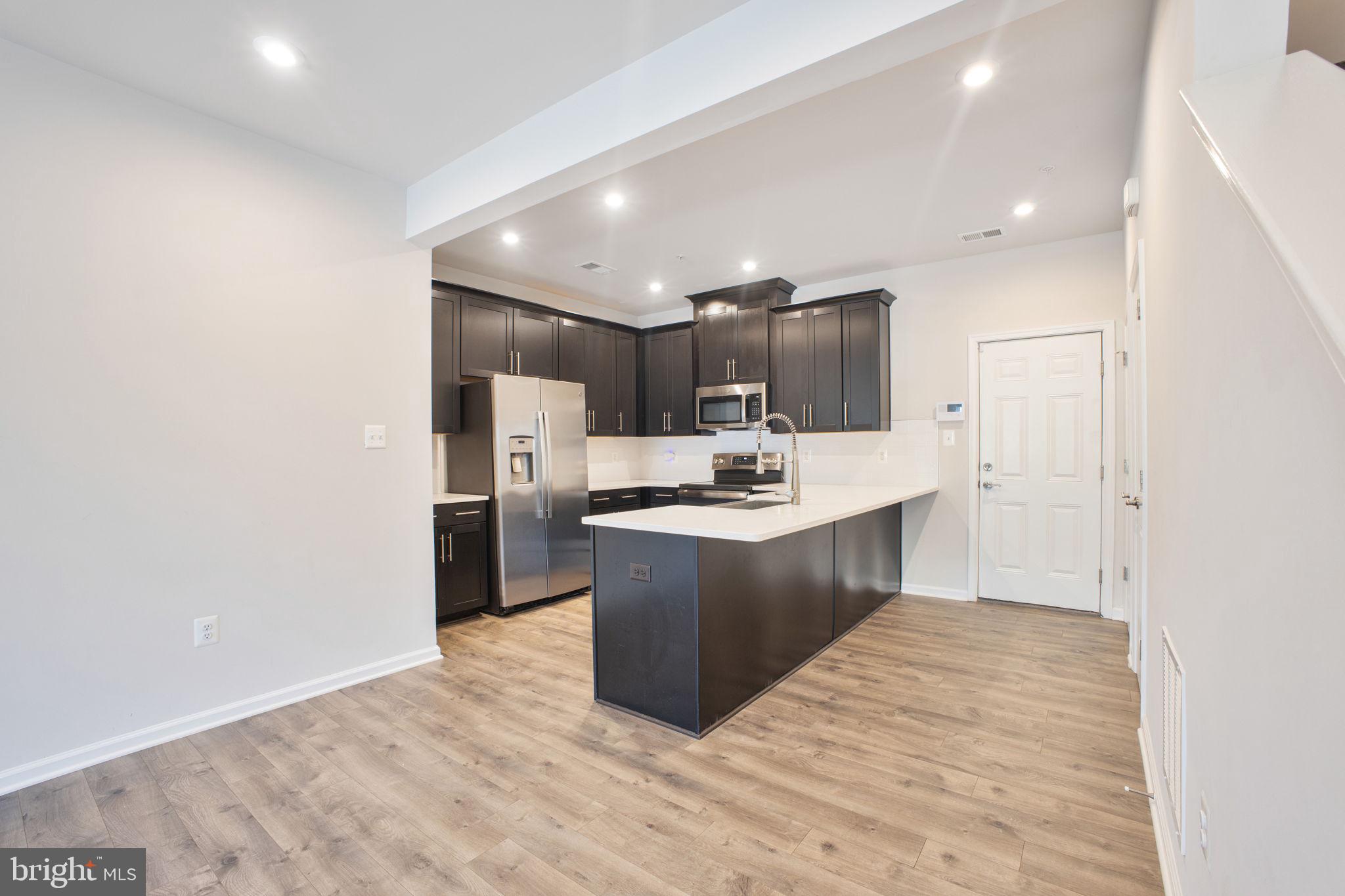 10517 Sally Ride Lane Lanham, MD 20706 - Photo 5 of 37 a large kitchen with a large counter top appliances and cabinets