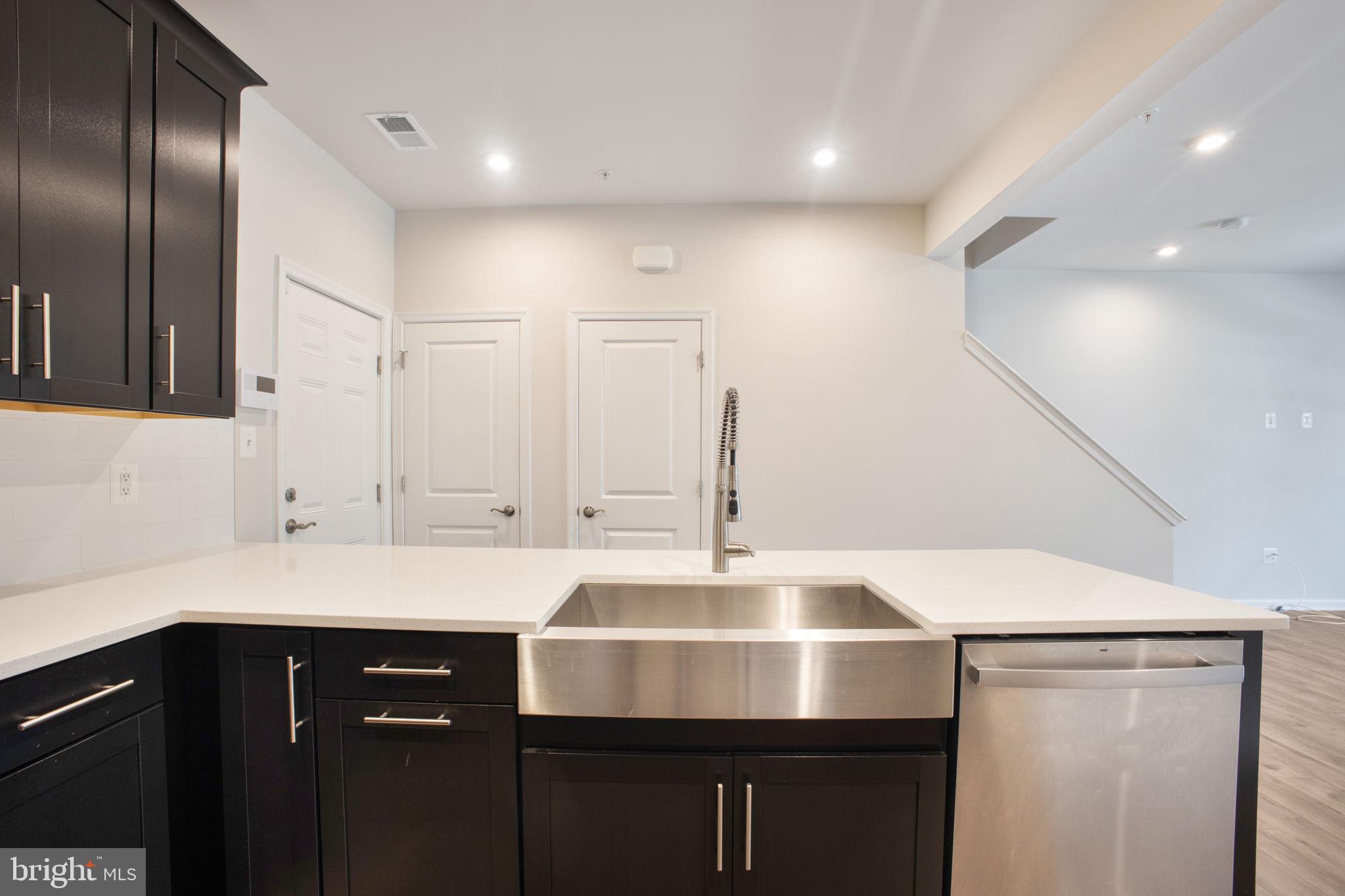 10517 Sally Ride Lane Lanham, MD 20706 - Photo 10 of 37 a kitchen with a sink cabinets and stainless steel appliances