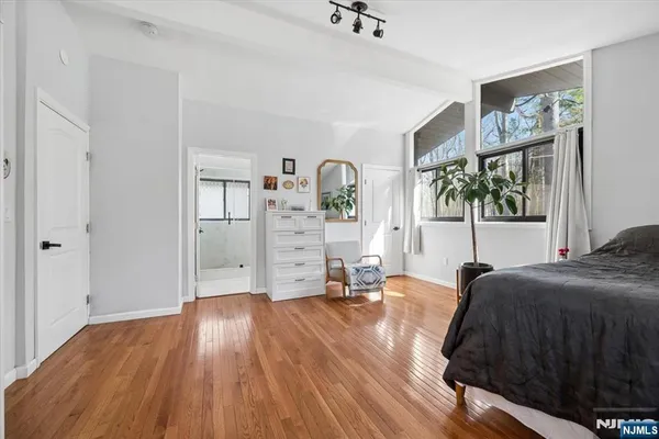 a living room with furniture and a dining table with wooden floor