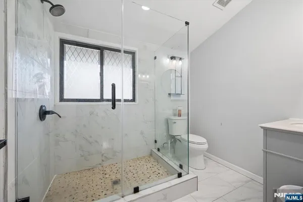 a bathroom with a toilet sink vanity and mirror