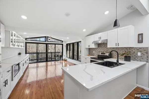 a kitchen that has a stove and a view of living room
