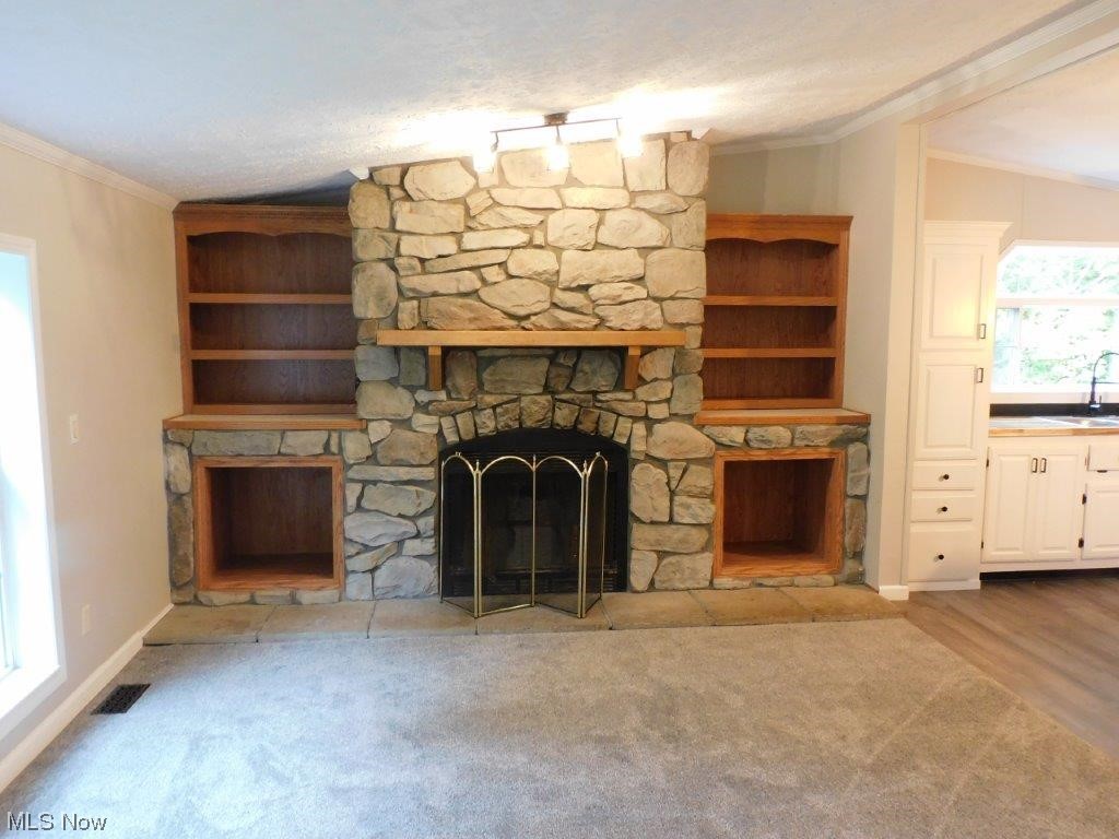 6045 Gore Road Ashtabula, OH 44004 - Photo 13 of 23 family room wood burning fireplace featuring light carpet, a stone fireplace, a wealth of natural light, and lofted ceiling