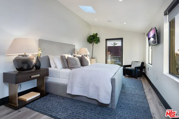 a bed sitting in a spacious bedroom next to a window