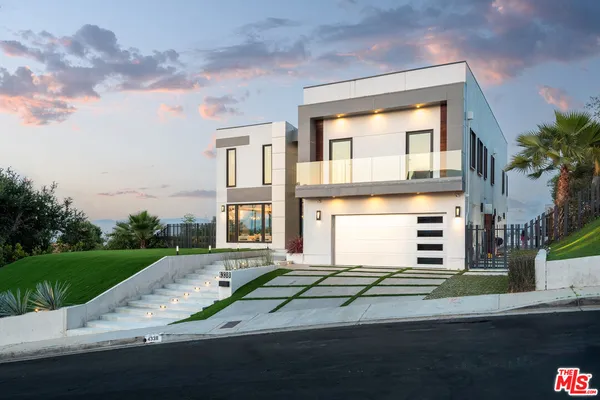 a front view of a house with a garden and yard
