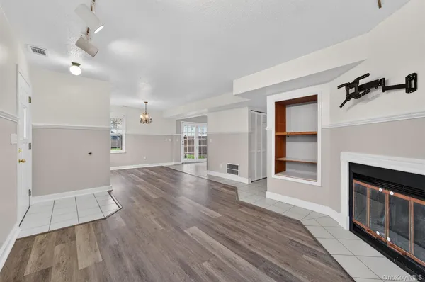 an empty room with wooden floor and fireplace