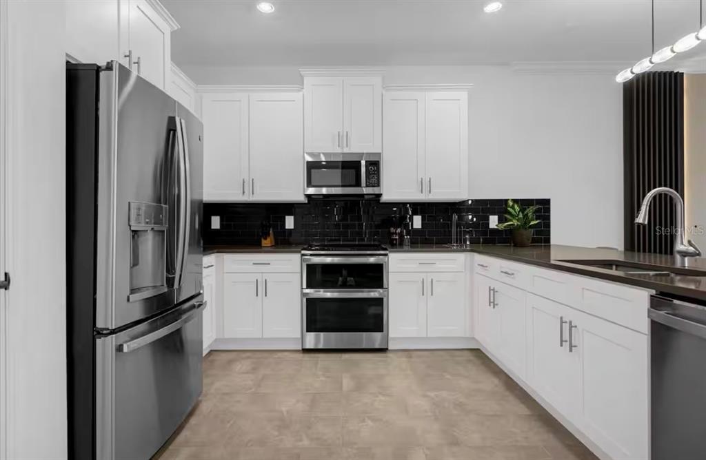 2992 Penelope Loop Kissimmee, FL 34746 - Photo 15 of 83 a kitchen with a refrigerator stove and microwave